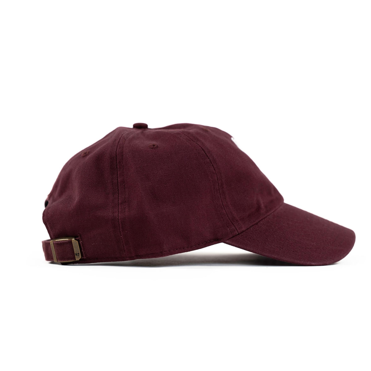 Dark maroon dad hat, side profile view with curved brim and brass buckle strap