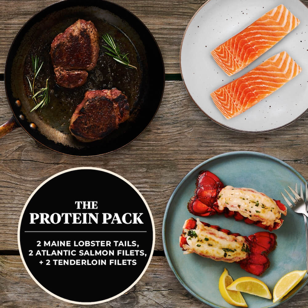 Dish featuring two Maine lobster tails, two Atlantic salmon fillets, and two tenderloin fillets on a wooden table with text overlay that says "The Protein Pack."