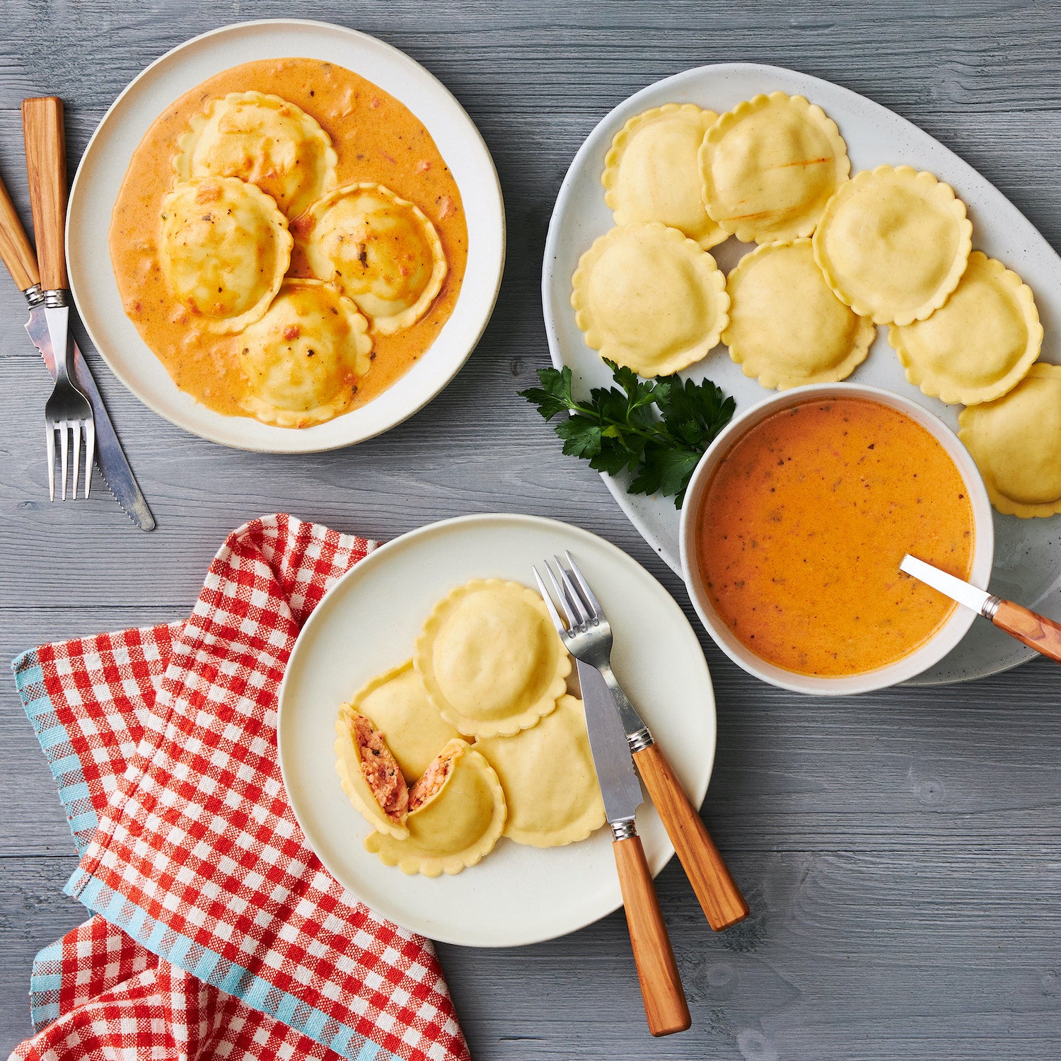 This Photograph features a spread of our Lobster Ravioli across three plates, One shows the raviolis alongside a sauce, ready to be served, the second plate shows 4 Ravioli on a plate, with one cut in half revealing the beautiful filling inside as well as the third plate showing the ravioli covered in a beautiful sauce (Not included) and ready to be enjoyed! 