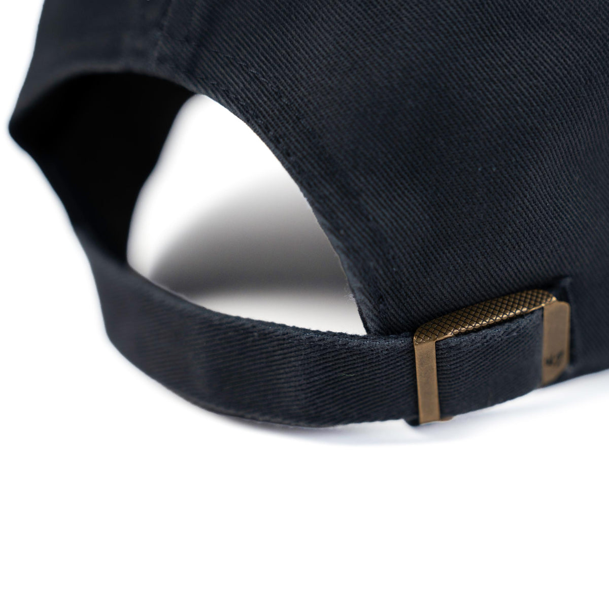Close-up of vintage navy dad hat adjustable strap with antique brass slide buckle closure
