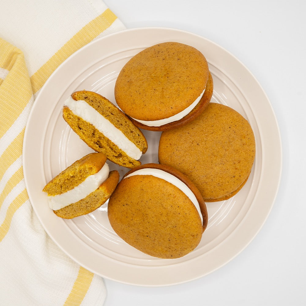 4 Pumpkin Spice Whoopie Pies, Plated alongside a yellow and white towel